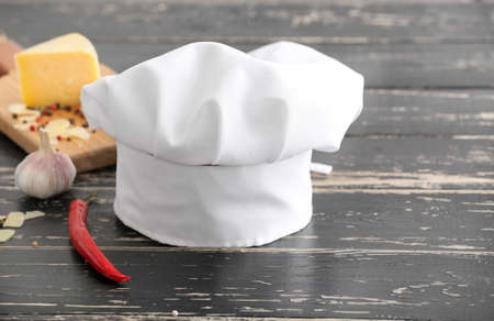 Chef's hat and products on table in kitchenの写真素材