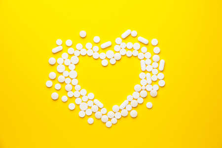 Heart made of pills on color backgroundの写真素材