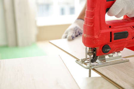 Carpenter installing laminate flooring in roomの写真素材