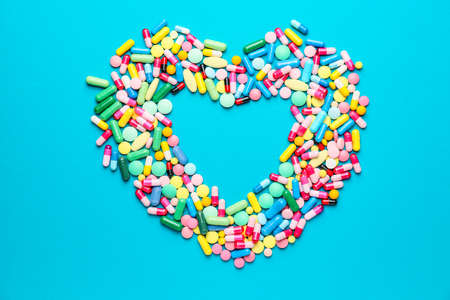 Heart made of pills on color backgroundの写真素材
