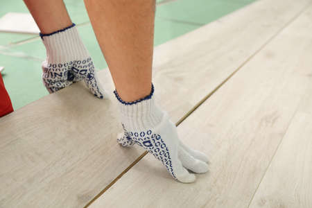 Carpenter installing laminate flooring in roomの写真素材