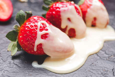 Tasty strawberry with melted chocolate on dark backgroundの写真素材