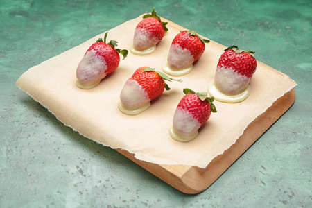 Tasty strawberry dipped in chocolate on color background