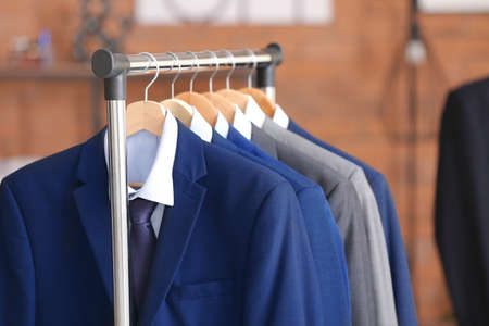 Hanger with different stylish male suits in storeの写真素材