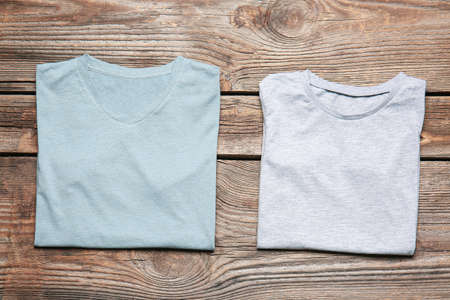 Different stylish t-shirts on wooden backgroundの写真素材