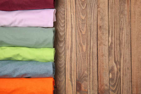 Different stylish t-shirts on wooden backgroundの写真素材