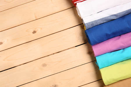 Different stylish t-shirts on wooden backgroundの写真素材