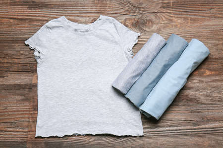 Different stylish t-shirts on wooden backgroundの写真素材