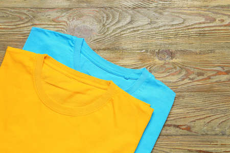 Different stylish t-shirts on wooden backgroundの写真素材