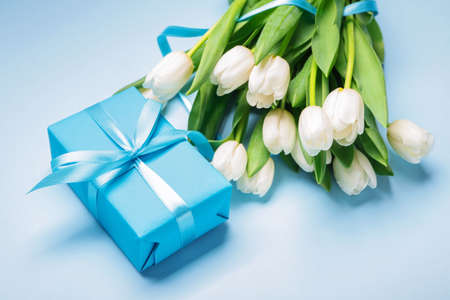 Gift and beautiful flowers on color backgroundの写真素材