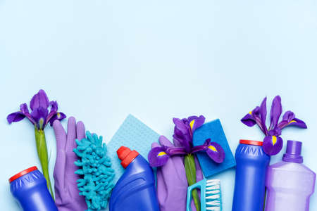 Set of cleaning supplies and spring flowers on color backgroundの写真素材