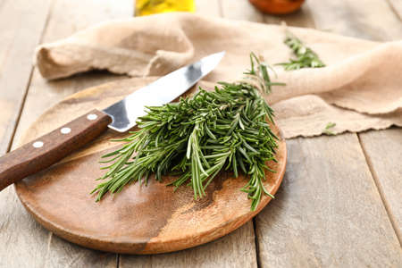 Plate with fresh rosemary and knife on tableの写真素材
