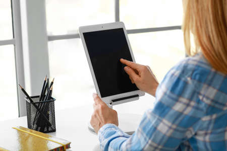 Mature woman using tablet computer for online learning at home