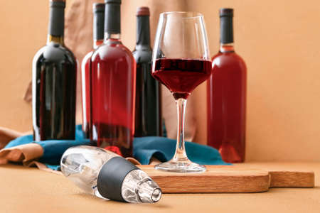 Aerator with glass and bottles of wine on color backgroundの写真素材