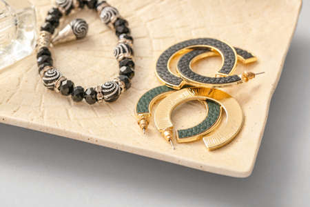 Plate with beautiful jewelry on light backgroundの写真素材