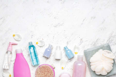 Shower gels with bath supplies on light background