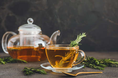 Cup of hot tea with rosemary on dark backgroundの写真素材