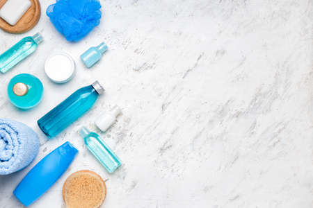 Shower gels with bath supplies on light background