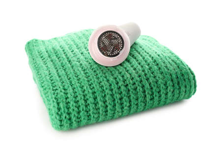 Modern fabric shaver and clothes on white background