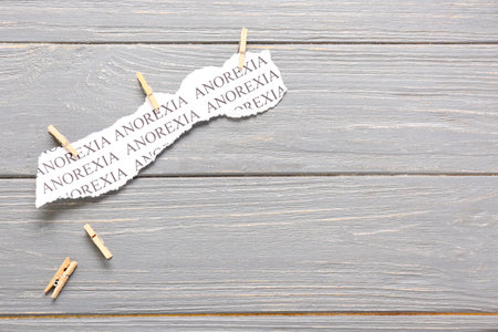 Piece of paper with text ANOREXIA on gray wooden backgroundの写真素材