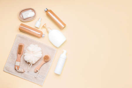 Shower gels with bath supplies on color background