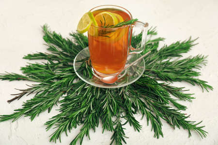 Cup of hot tea with rosemary on tableの写真素材