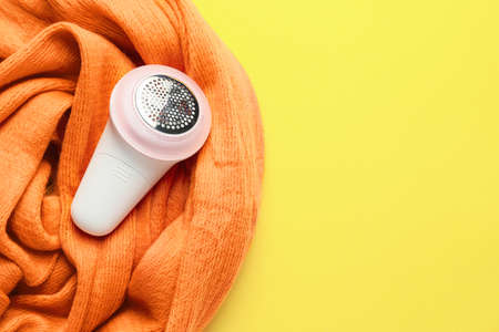 Modern fabric shaver and clothes on color backgroundの写真素材