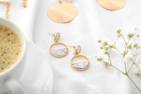 Beautiful jewelry and flowers on white cloth