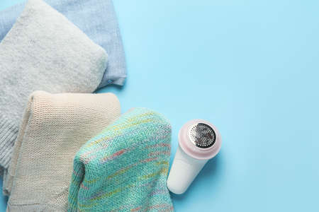 Modern fabric shaver and clothes on color backgroundの写真素材