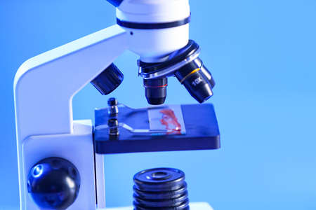 Microscope with blood sample in laboratory. Concept of coronavirus epidemicの写真素材