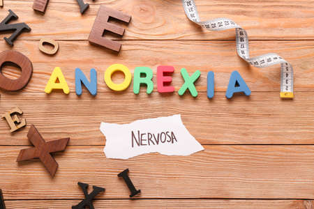 Text ANOREXIA NERVOSA with measuring tape on wooden backgroundの写真素材