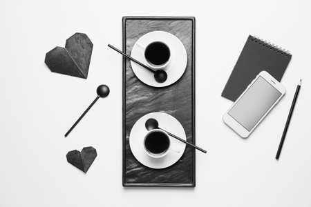 Composition with cups of coffee, mobile phone and notebook on white backgroundの写真素材