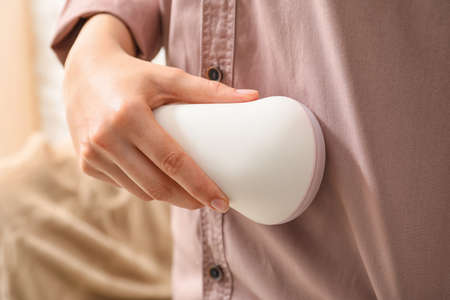Woman using fabric shaver at home, closeupの写真素材