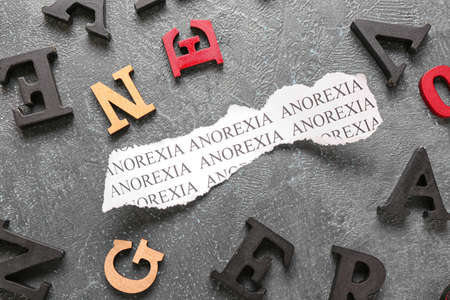 Piece of paper with text ANOREXIA on gray backgroundの写真素材