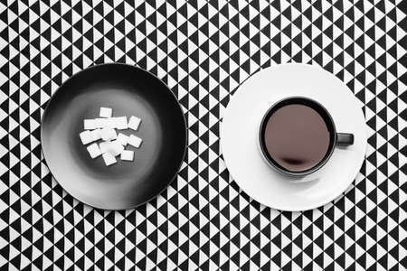 Composition with cup of coffee and sugar on black and white backgroundの写真素材