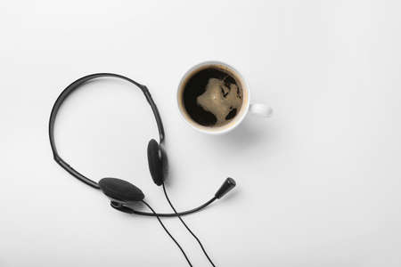 Headset and cup of coffee on white backgroundの写真素材