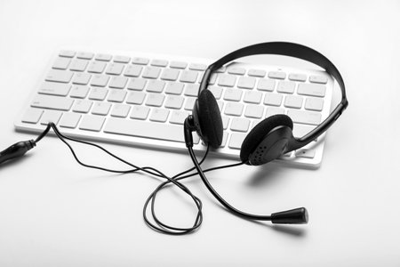 PC keyboard with headset on white backgroundの写真素材