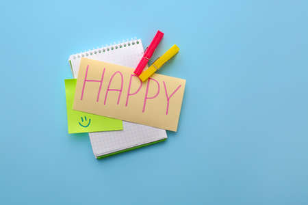 Notebook with word HAPPY on color backgroundの写真素材