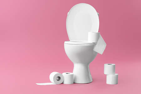 Toilet bowl with rolls of paper on color backgroundの写真素材