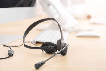 Headset and computer on table of technical support agent in officeの写真素材