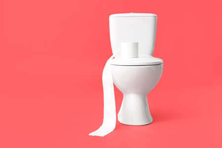 Toilet bowl with roll of paper on color backgroundの写真素材