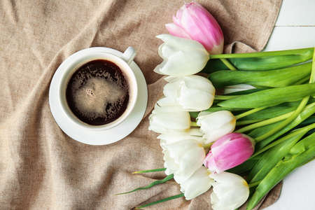 Cup of coffee and bouquet of flowers on tableの写真素材