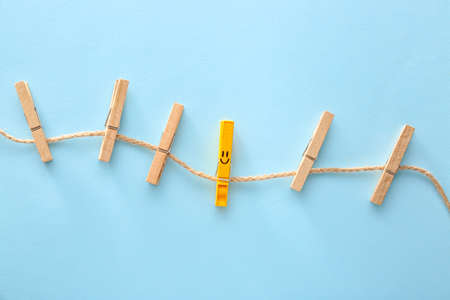 Clothes pegs with drawn smile on color backgroundの写真素材