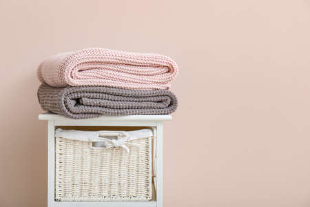 Soft warm plaids on shelf unit near wallの写真素材