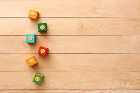 Cubes with paper smiles on wooden backgroundの写真素材