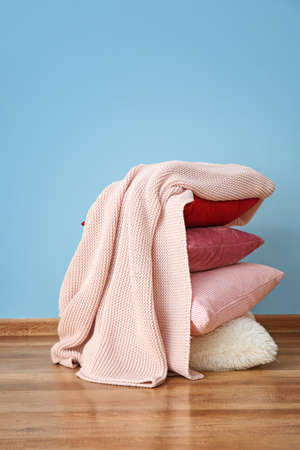 Soft warm plaid and pillows near color wallの写真素材