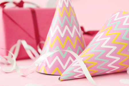 Party hats, gift and decor on color backgroundの写真素材