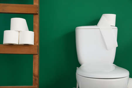 Toilet bowl with paper near color wall in restroomの写真素材