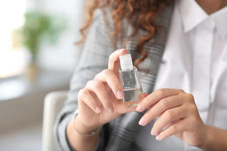 African-American businesswoman with disinfectant in office closeupの写真素材