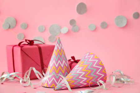 Party hats, gift and decor on color backgroundの写真素材